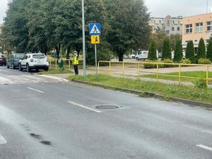 Policjantka RD stoi przed przejściem dla pieszych w pobliżu szkoły