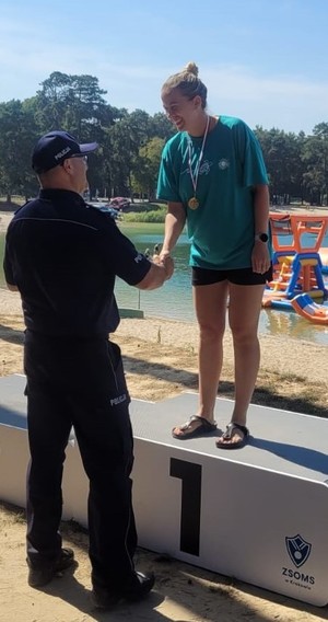 Policjanci na podium zawodów pływackich.