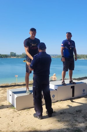 Policjanci na podium zawodów pływackich.