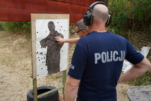 policjanci biegną przez przeszkody i strzelają z pistoletów do tarcz na strzelnicy