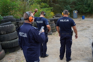 policjanci biegną przez przeszkody i strzelają z pistoletów do tarcz na strzelnicy