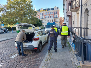 Funkcjonariusze kontrolują kierowcę i samochód z napisem taxi