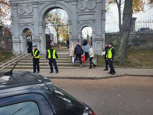 Policjanci stoją przed wejściem na cmentarz