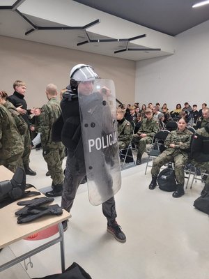 policjanci Oddziału Prewencji Policji w Bydgoszczy rozmawiają z uczniami i pokazują policyjny sprzęt