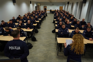 policjanci siedzą w ławkach, przed nimi stoją policjanci odpowiedzialni za szkolenie funkcjonariuszy oraz Zastępca Komendanta Wojewódzkiego Policji w Bydgoszczy