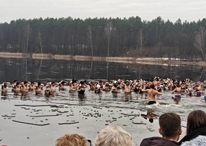 Policjanci pokazują wyposażenie policyjnego radiowozu uczestnikom akcji charytatywnej