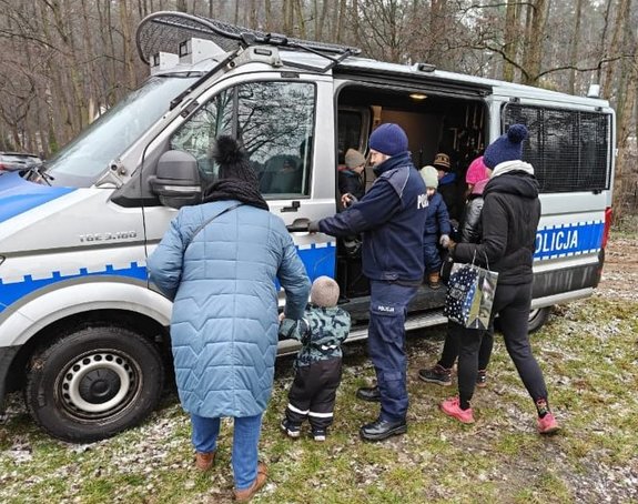 Policjanci pokazują wyposażenie policyjnego radiowozu uczestnikom akcji charytatywnej