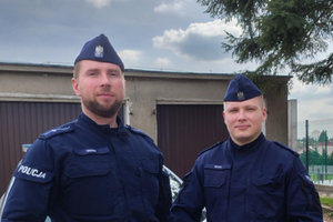 dwaj umundurowani policjanci pozują do zdjęcia
