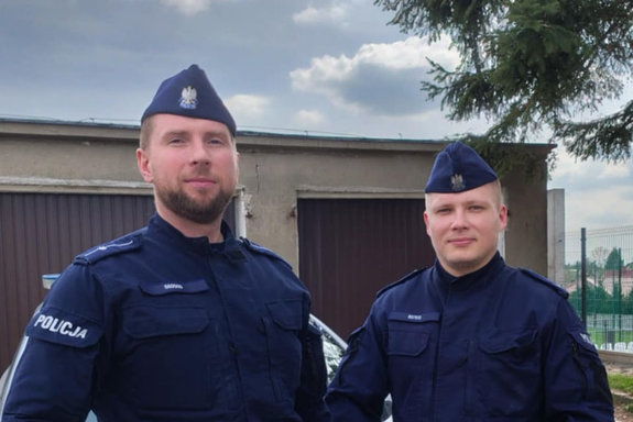 dwaj umundurowani policjanci pozują do zdjęcia