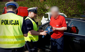 policjant pokazu kierowcy wynik pomiaru na ręcznym mierniku prędkości