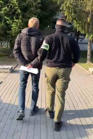 policjant prowadzi zatrzymanego