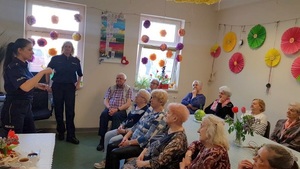 Dwie policjantki stoją przed Seniorami i jedna z nich mówi do uczestników Dziennego Domu Pomocy Virtus w Bydgoszczy