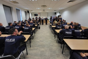 policjanci siedzą w ławkach na sali