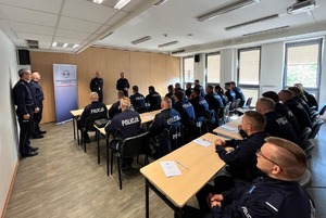 Komendant przemawia do policjantów siedzących w ławkach