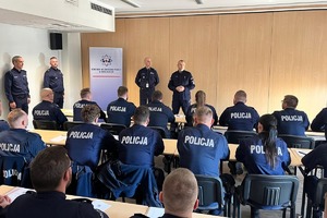 Komendant przemawia do policjantów siedzących w ławkach