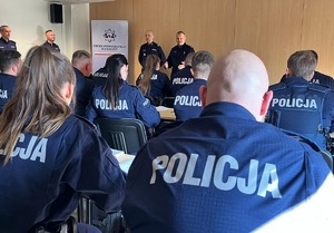 Komendant przemawia do policjantów siedzących w ławkach