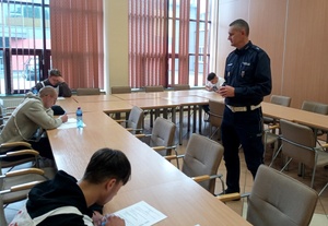 Policjant w trakcie testu wiedzy z przepisów ruchu drogowego