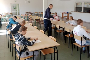 dzieci biorą udział w Wojewódzkim Turnieju Bezpieczeństwa w Ruchu Drogowym dla uczniów Szkół Specjalnych, piszą test i jeżdżą rowerem obok policjanta