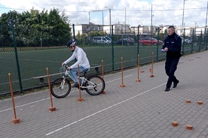 dzieci biorą udział w Wojewódzkim Turnieju Bezpieczeństwa w Ruchu Drogowym dla uczniów Szkół Specjalnych, piszą test i jeżdżą rowerem obok policjanta
