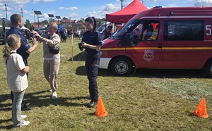 Policjanci wzięli udział w pikniku profilaktycznym w Osiu, pokazują uczestnikom policyjny sprzęt i biorą udział w zabawach z najmłodszymi