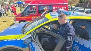 Policjanci wzięli udział w pikniku profilaktycznym w Osiu, pokazują uczestnikom policyjny sprzęt i biorą udział w zabawach z najmłodszymi