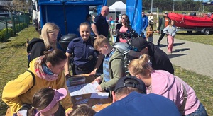 Policjanci wzięli udział w pikniku profilaktycznym w Osiu, pokazują uczestnikom policyjny sprzęt i biorą udział w zabawach z najmłodszymi