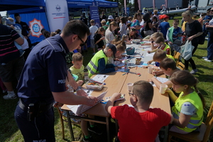 Piknik w Żninie z okazji inauguracji akcji Kręci mnie bezpieczeństwo w lecie. Dzieci i młodzież oglądają stanowiska różnych służb