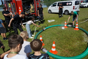 Piknik w Żninie z okazji inauguracji akcji Kręci mnie bezpieczeństwo w lecie. Dzieci i młodzież oglądają stanowiska różnych służb