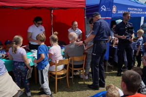 Piknik w Żninie z okazji inauguracji akcji Kręci mnie bezpieczeństwo w lecie. Dzieci i młodzież oglądają stanowiska różnych służb