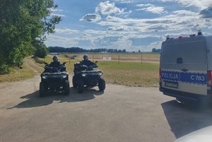 dwaj policjanci siedzą na dwóch quadach