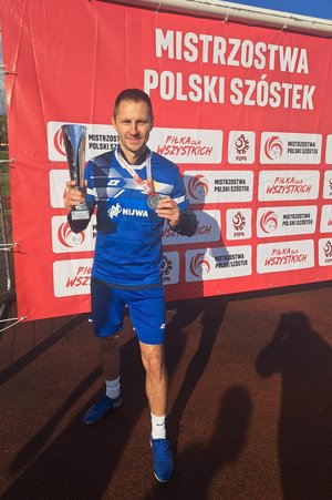 policjant pozuje z pucharem i medalem do zdjęcia