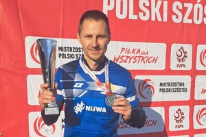 policjant pozuje z pucharem i medalem do zdjęcia