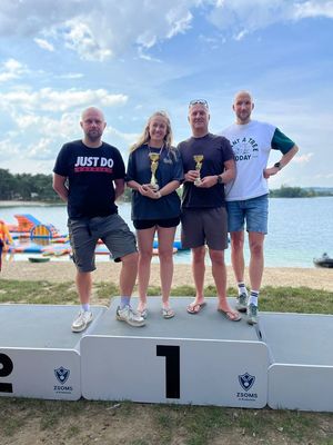 Osoby na podium podczas zawodów nad wodą.