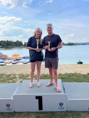 Osoby na podium podczas zawodów nad wodą.