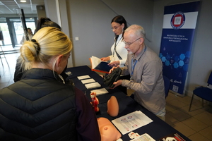 Kobiety uczestniczą w zajęciach, rozmawiają i badają się na poszczególnych stanowiskach