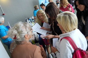 Kobiety uczestniczą w zajęciach, rozmawiają i badają się na poszczególnych stanowiskach