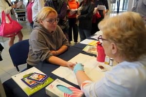 Kobiety uczestniczą w zajęciach, rozmawiają i badają się na poszczególnych stanowiskach