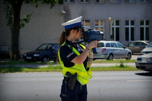 Policjantka w czasie pomiaru prędkości na drodze.