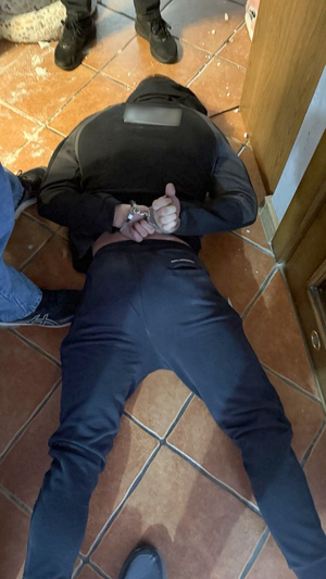 zatrzymany leży skuty kajdankami na podłodze