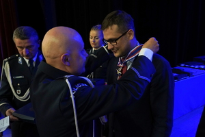 policjanci i pracownicy cywilni biorą udział z okazji rocznicy związków zawodowych, które odbywają się w wojskowym kinoteatrze. Przedstawiciele odznaczają wyróżnionych