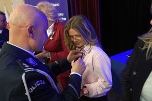 policjanci i pracownicy cywilni biorą udział z okazji rocznicy związków zawodowych, które odbywają się w wojskowym kinoteatrze. Przedstawiciele odznaczają wyróżnionych