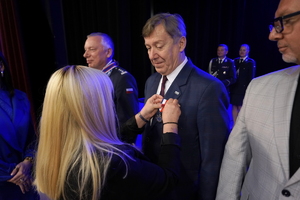 policjanci i pracownicy cywilni biorą udział z okazji rocznicy związków zawodowych, które odbywają się w wojskowym kinoteatrze. Przedstawiciele związków odznaczają wyróżnionych