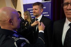 policjanci i pracownicy cywilni biorą udział z okazji rocznicy związków zawodowych, które odbywają się w wojskowym kinoteatrze. Przedstawiciele związków odznaczają wyróżnionych