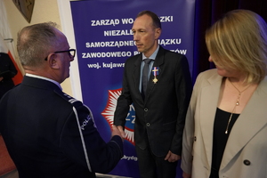 policjanci i pracownicy cywilni biorą udział z okazji rocznicy związków zawodowych, które odbywają się w wojskowym kinoteatrze. Przedstawiciele związków odznaczają wyróżnionych