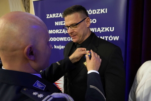 policjanci i pracownicy cywilni biorą udział z okazji rocznicy związków zawodowych, które odbywają się w wojskowym kinoteatrze. Przedstawiciele związków odznaczają wyróżnionych