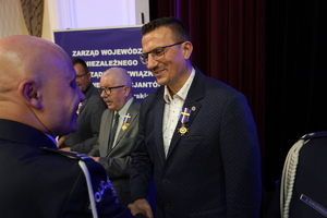 policjanci i pracownicy cywilni biorą udział z okazji rocznicy związków zawodowych, które odbywają się w wojskowym kinoteatrze. Przedstawiciele związków odznaczają wyróżnionych