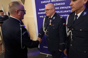 policjanci i pracownicy cywilni biorą udział z okazji rocznicy związków zawodowych, które odbywają się w wojskowym kinoteatrze. Przedstawiciele związków odznaczają wyróżnionych
