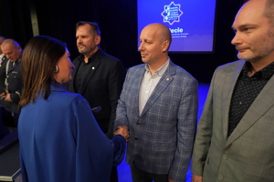 policjanci i pracownicy cywilni biorą udział z okazji rocznicy związków zawodowych, które odbywają się w wojskowym kinoteatrze. Przedstawiciele związków odznaczają wyróżnionych