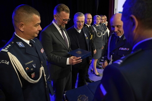 policjanci i pracownicy cywilni biorą udział z okazji rocznicy związków zawodowych, które odbywają się w wojskowym kinoteatrze. Przedstawiciele związków odznaczają wyróżnionych