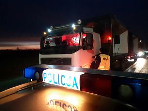 Stoi radiowóz dalej ciężarówka i policjant podchodzi do kierowcy z alkoatem